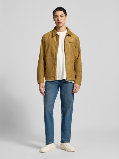 Męski model nosi Regular Tapered Fit Jeans im Used-Look od Dickies, niebieski jeans, bawełna, kieszenie, szerokość w rozmiarze 32/32: 40 cm, długość nogawki wewnętrznej: 80 cm, cała sylwetka z przodu.