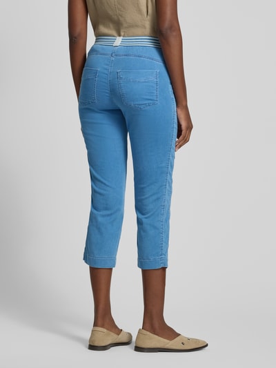 Frauenmodel trägt Jogpants mit elastischem Bund Modell 'Sue' von TONI aus Baumwoll-Mix mit Stretch-Anteil, 3/4-Fit, seitliche Eingrifftaschen, Gesäßtaschen, Farbe mittelblau, Textur glatter Stoff, Ganzkörperansicht Rückansicht.