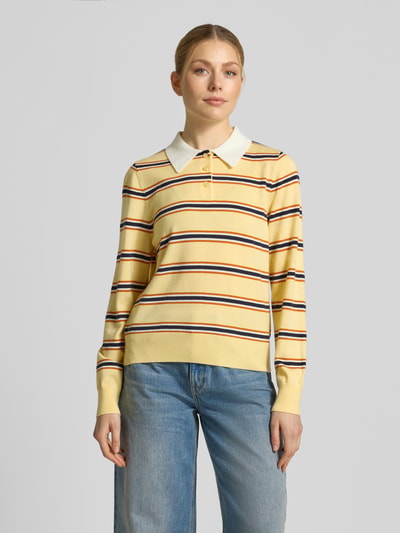 Frauenmodel trägt Regular Fit Poloshirt mit Knopfleiste Modell 'PREGO' von SUNCOO PARIS, gelb gestreift, Material-Mix mit Lanawoll-Anteil, Rückenlänge bei Größe S 56 cm, Ärmellänge 64 cm, Ganzkörperansicht von vorne.