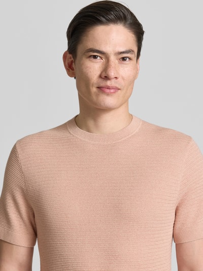 Männermodel trägt Strickshirt mit Rundhalsausschnitt Modell 'RILEY' von Jack & Jones Premium aus Reine Baumwolle, Strukturmuster, Slim-Fit, Nahaufnahme Oberkörper.
