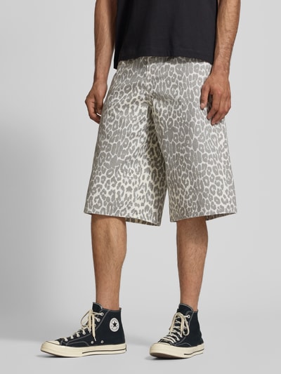 Männermodel trägt Shorts im Allover-Look Modell 'OWEN' von Jack & Jones aus reiner Baumwolle im Relaxed-Fit mit Eingrifftaschen, Ganzkörperansicht von vorne. Bundweite 44 cm, Innenbeinlänge 37 cm, grau-weißes Muster.