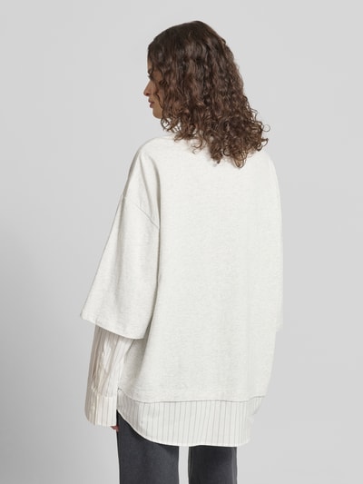 Frauenmodel trägt Oversized Longsleeve in Layering-Optik von Karo Kauer aus reiner Baumwolle mit Rundhalsausschnitt, Rückenansicht.