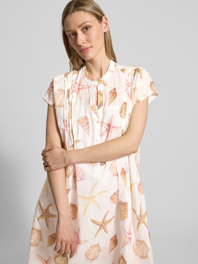 Frauenmodel trägt Knielanges Kleid mit Tunikakragen von Emily Van den Bergh, Reine Baumwolle, Taillierter Schnitt, Knielänge, Biesen, kurze Knopfleiste, Rückenlänge 96 cm, Brustweite 54 cm, Ganzkörperansicht von vorne.