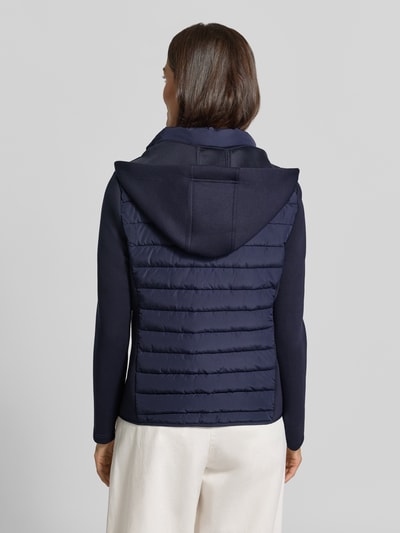 Vrouwenmodel draagt Steppjacke mit Kapuze und Reißverschlusstaschen van Christian Berg Woman Selection in donkerblauw, regular fit, ruglengte maat 36: 59 cm, schouderbreedte 41 cm, borstwijdte 50 cm, mouwlengte 65 cm, volledige rugaanzicht.