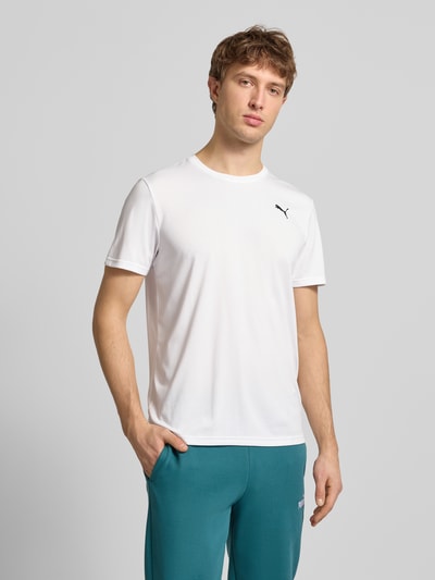 Männermodel trägt T-Shirt mit Logo und Rundhalsausschnitt von PUMA PERFORMANCE in Weiß, Regular Fit, glatte Textur, Ganzkörperansicht von vorne.