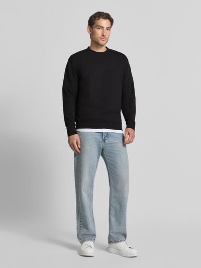 Mannelijk model draagt zwarte slim fit pullover uit pure katoen 'TOM' van Selected, heren sweatshirt, volledige lichaamsvooraanzicht.