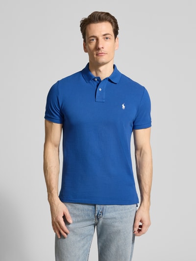 Männermodel trägt Regular Fit Poloshirt aus reiner Baumwolle von Polo Ralph Lauren, unifarben blau, Piqué-Struktur, Logo-Detail, Ganzkörperansicht von vorne.