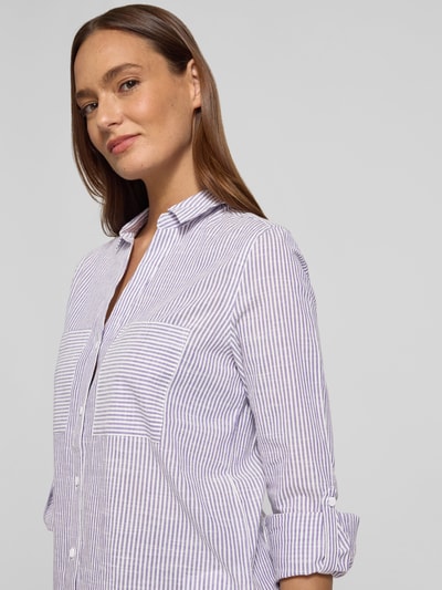 Frauenmodel trägt Regular Fit Bluse mit V-Ausschnitt und Brusttaschen von Christian Berg Woman, weiß-lila Streifen, Baumwolle, Nahaufnahme Oberkörper.