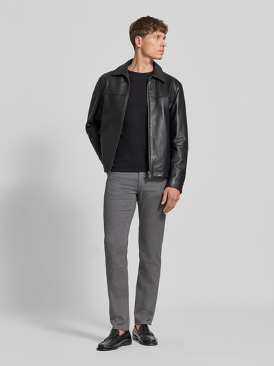 Männermodel trägt Stoffhose aus Baumwoll-Mix mit Viskose-Anteil Modell 'Cadiz' von Brax in Melange-Grau, Straight Fit, Ganzkörperansicht von vorne.