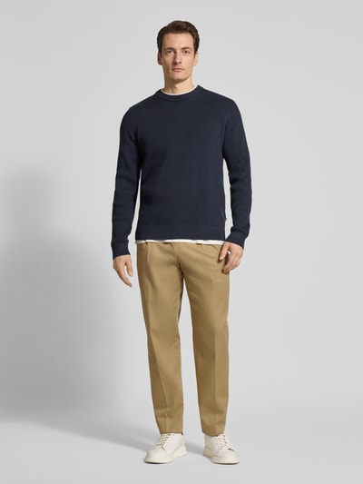 Männermodel trägt Relaxed Fit Strickpullover mit Rundhalsausschnitt von Lindbergh, dunkelblau, Ripp-Optik, Baumwoll-Mix, Ganzkörperansicht von vorne.