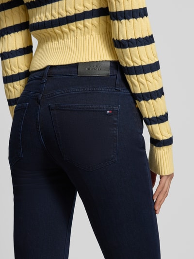 Frauenmodel trägt Regular Fit Bootcut Jeans aus Baumwoll-Mix von Tommy Hilfiger in Melange-Optik mit Label Patch, Detailaufnahme Rückansicht.