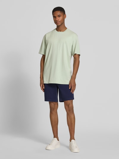 Männermodel trägt Regular Fit Chinoshorts aus Baumwoll-Mix Modell 'CHINO' von Armedangels in Dunkelblau, Optik: Unifarben, Label-Applikation, Gürtelschlaufen, Knopf und verdeckter Reißverschluss, Eingrifftaschen, Gesäßtasche, Passform: Regular-Fit, Material: Baumwoll-Mix, Ganzkörperansicht von vorne.