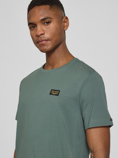 Männermodel trägt PME Legend T-Shirt mit Label-Stitching Modell 'GUYVER' in Grün, Baumwoll-Elasthan-Mix, Nahaufnahme Oberkörper.