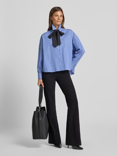 Frauenmodel trägt schwarze Regular Fit Schlaghose aus Viskose-Mix Modell 'NANOU' von SEDUCTIVE, kombiniert mit blauer Bluse, Ganzkörperansicht von vorne. Damen Schlaghose von SEDUCTIVE.