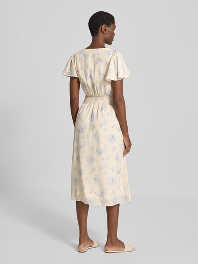 Frauenmodel trägt Midikleid mit Knopfleiste Modell 'Eleni' von Neo Noir in Creme mit blauem Allover-Blumenmuster, A-Linie, Ganzkörperansicht Rückansicht.