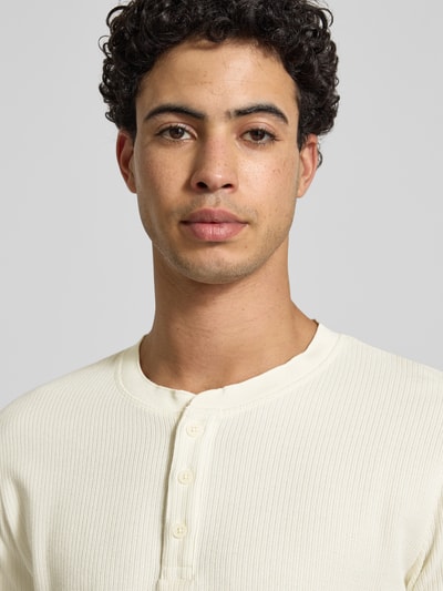 Männermodel trägt Regular Fit Longsleeve in Strick-Optik Modell 'Niagara' von JACK & JONES, Baumwoll-Mix, Henley-Ausschnitt, Nahaufnahme Oberkörper.