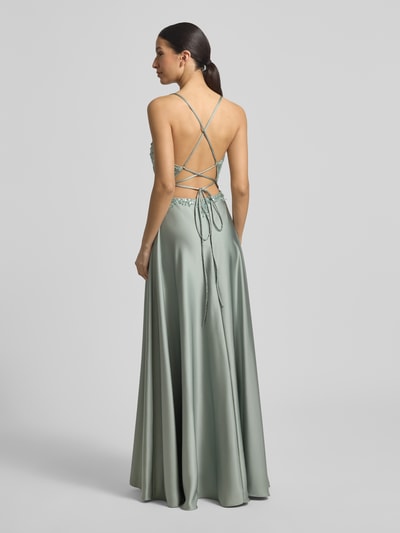 Modelka kobieca nosi Abendkleid mit Perlen und V-Ausschnitt von Laona, satyn, krój taliowany, długi fason, perły, dekolt V, długość tyłu w rozmiarze 36: 144 cm, szerokość w rozmiarze 36: 30 cm, pastelowa zieleń, lekko połyskująca tekstura, całkowity widok z tyłu.