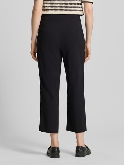 Vrouwenmodel draagt Hose aus Viskose-Mix in verkürzter Passform Modell 'FENJA2' van STEHMANN in zwart, rechte pijpen, elastische tailleband, viscosemix met stretch, verkorte fit, detail van de bandmaat en binnenbeenlengte bij maat 36, volledige lichaamsweergave achteraan.
