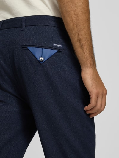 Männermodel trägt Hose aus Baumwoll-Woll-Mix mit Gesäßtaschen Modell 'STUART' von Scotch & Soda, dunkelblauer Stoff, Detailaufnahme, Kontext: Slim Fit, Bundweite 45 cm, Innenbeinlänge 80 cm.
