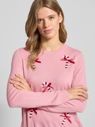 Modelka kobieca nosi różowy Regular Fit Weihnachtspullover mit Pailletten-Motiv Modell 'XMAS SHINE' od ONLY, dzianina, długi rękaw, aplikacje z cekinów, widok z przodu, zbliżenie górnej części ciała.