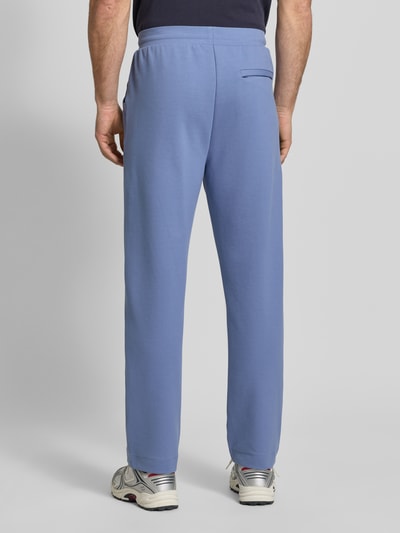 Männermodel trägt Regular Fit Sweatpants aus Baumwoll-Mix Modell 'JT_Member Hurley' von BOSS Green in Hellblau mit Bügelfalten, unifarben, Ganzkörperansicht Rückansicht.