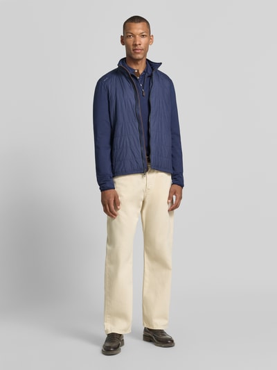 Mannenmodel draagt Relaxed Fit Sweatjacke met ritssluiting van Polo Ralph Lauren in donkerblauw, lichte broek, Ganzkörperansicht von vorne.