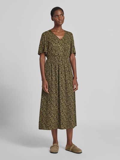 Frauenmodel trägt Tailliertes Freizeitkleid aus reiner Viskose von Marc O'Polo, olivgrünes Muster, fließende Textur, Ganzkörperansicht von vorne. Damen Freizeitkleid von Marc O'Polo.