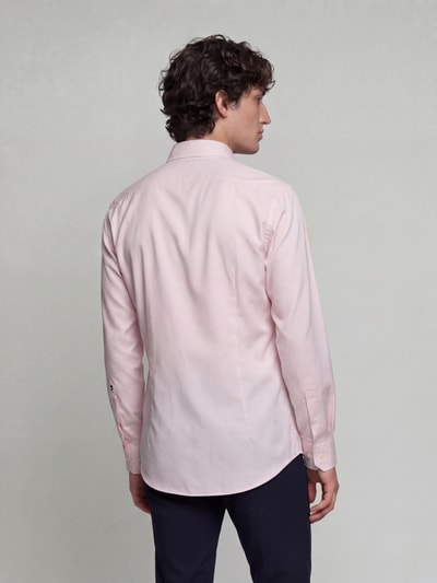 Männermodel trägt Regular Fit Businesshemd aus reiner Baumwolle Modell 'New Kent' von Seidensticker in zartem Rosa, Ganzkörperansicht Rückansicht. Herren Businesshemd von Seidensticker.