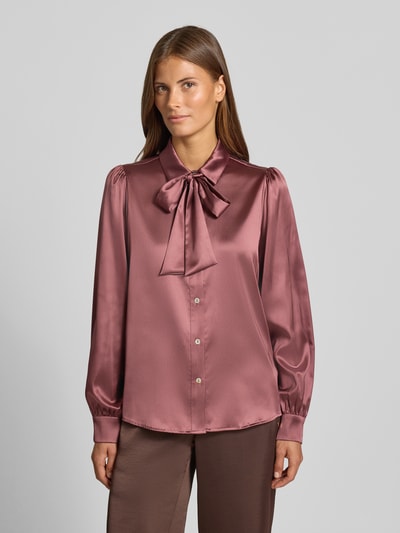 Vrouwenmodel draagt Regular Fit Hemdbluse aus Satin van Christian Berg Woman Selection in glanzende satijn, met sierstrik, overhemdkraag en lange mouwen, kleur oudroze, detailopname van bovenlichaam.