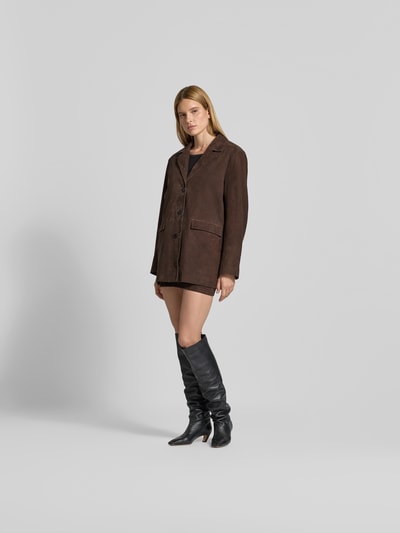 Frauenmodel trägt Blazer aus echtem Ziegenvelours von ROTATE in Dunkelbraun mit Oversized Fit, Reverskragen und Pattentaschen, Ganzkörperansicht von vorne.