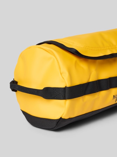 Produktfoto, Travel Canister mit Logo-Print von The North Face in Gelb und Schwarz, Hauptfach mit Reißverschluss, Tragehenkel, Innenfach, Breite 28 cm, Länge 14 cm, Tiefe 17 cm