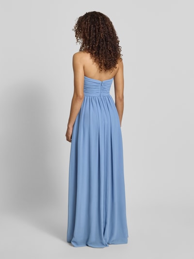 Frauenmodel trägt Maxikleid im Off-Shoulder-Look von Mascara aus blauem Chiffon, Taillierter Schnitt, Rückenreißverschluss, Ganzkörperansicht Rückansicht.