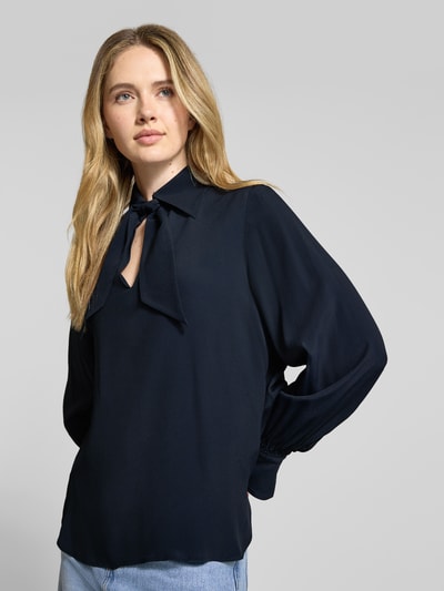 Frauenmodel trägt Schluppenbluse mit Schlüsselloch-Ausschnitt von LUISA CERANO, dunkelblauer Material-Mix mit Tussahseide-Anteil, Regular-Fit, Umlegekragen, Rückenlänge 65 cm, Ärmellänge 62 cm, Nahaufnahme Oberkörper.