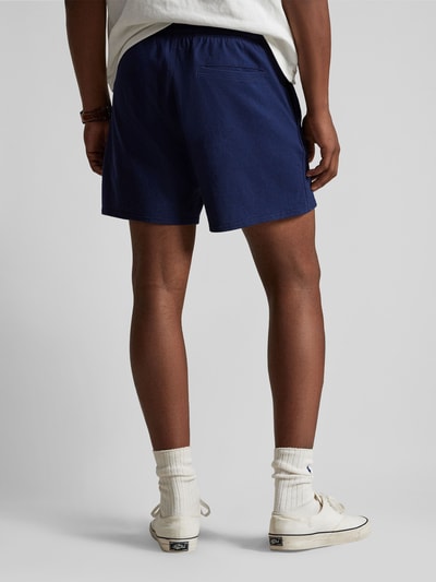 Männermodel trägt Regular Fit Sweatshorts aus reiner Baumwolle von Polo Ralph Lauren, unifarben, mit Label Stitching, Ganzkörperansicht Rückansicht.