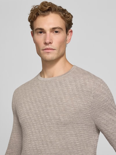 Männermodel draagt wollen trui met structuurpatroon Model 'Connor' van Tiger of Sweden, zuiver wol, recht model, ronde hals, kleur lichtbeige, Nahaufnahme Oberkörper.