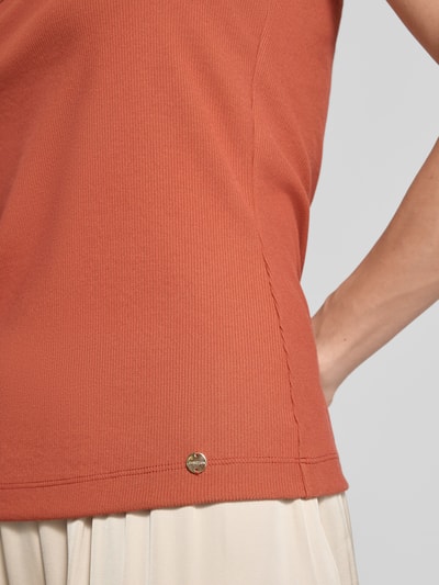 Vrouwenmodel draagt Tanktop met Karree-Ausschnitt van Marc Cain in roestbruin, modalmix met stretch, fijnrib, labeldetail, nauwsluitend model, ruglengte bij maat 36: 50 cm, detailopname zijkant