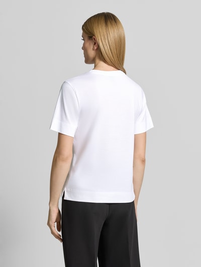 Frauenmodel trägt Regular Fit T-Shirt aus reiner Baumwolle Modell 'ELPHA' von BOSS, weiß, Rundhals, Kurzarm, Jersey, Motiv-Print, Label-Print, Ganzkörperansicht Rückansicht.
