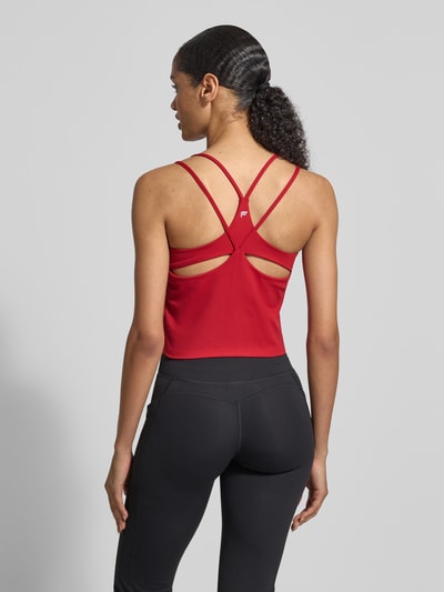 Frauenmodel trägt Cropped Trägertop mit integriertem BH Modell 'PRINCIPLE' von Fabletics in Rot, Racerback, Material-Mix mit Stretch-Anteil, Ganzkörperansicht Rückansicht, Rückenlänge bei Größe S 20 cm.