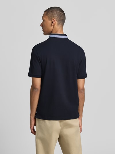 Männermodel trägt Regular Fit Poloshirt mit Stehkragen und Logo-Stitching von bugatti in Dunkelblau, reine Baumwolle, Rückansicht, Ganzkörperansicht.
