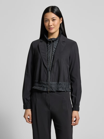 Kobiece model prezentuje Blazer mit Stehkragen von Marc Cain w kolorze czarnym, materiał z domieszką stretchu, kieszenie, długość 55 cm, Ganzkörperansicht von vorne.