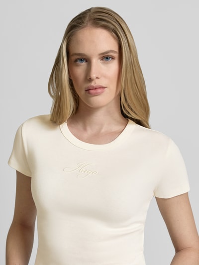 Kobiece model prezentuje damski t-shirt Slim Fit T-Shirt aus Baumwoll-Mix Modell 'DELANOR' von HUGO, efekt: jednolity kolor, okrągły dekolt, krótki rękaw, mieszanka bawełny, wyhaftowane logo, dżersej, zbliżenie na górną część ciała.