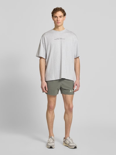 Männermodel trägt Shorts mit elastischem Bund von HALO, olivgrün, Regular Fit, Material-Mix, Label-Print, Ganzkörperansicht von vorne.