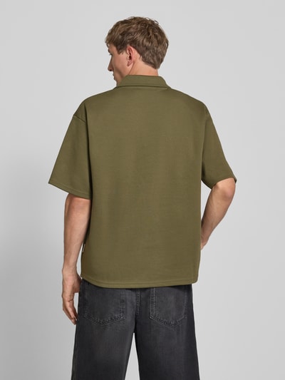 Männermodel trägt Regular Fit Poloshirt mit Logo Modell 'Eddie' van Redefined Rebel, katoenmix, olijfgroen, ruglengte maat M 73 cm, Ganzkörperansicht Rückansicht