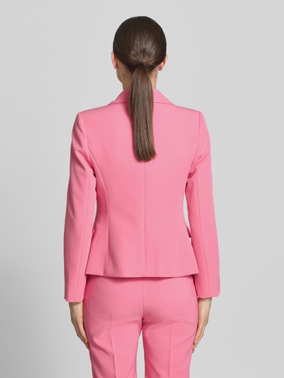 Frauenmodel trägt Blazer mit Pattentaschen Modell 'REWI' von Rinascimento in Pink, taillierter Schnitt, Doppelknopf, Material-Mix, Ganzkörperansicht Rückansicht.