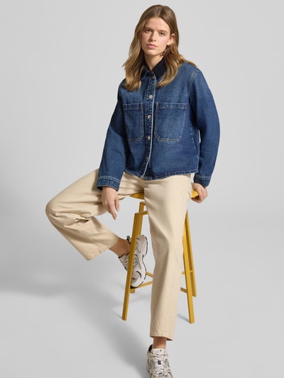 Frauenmodel trägt Oversized Jeansjacke aus Baumwoll-Mix Modell 'CASSIE' von Only in Unifarben-Optik mit Umlegekragen und Brusttaschen, Ganzkörperansicht von vorne.