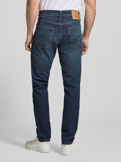 Męski model nosi Jeansy z 5 kieszeniami od LEVI'S®, mieszanka bawełny i elastanu, krój slim fit, granatowy, widok całej sylwetki z tyłu.
