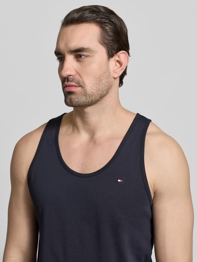 Männermodel trägt Regular Fit Tank Top aus reiner Baumwolle im 3er-Pack von Tommy Hilfiger, Optik: Unifarben, Logo-Stitching, breite Träger, Nahaufnahme Oberkörper.