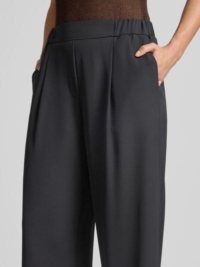 Frauenmodel trägt Wide Leg Stoffhose mit elastischem Bund von Jake*s Collection, dunkler Farbton, glatte Textur, Nahaufnahme Oberkörper.