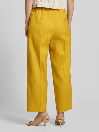 Frauenmodel trägt Wide Leg Hose aus Leinen-Mix von Windsor in Gelb mit Bügelfalten, Elastischer Bund, Damen, Ganzkörperansicht Rückansicht. Bundweite bei Größe 36: 38 cm, Innenbeinlänge: 67 cm, Lyocell-Anteil.