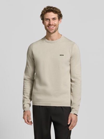 Männermodel trägt Regular Fit Pullover aus reiner Baumwolle Modell 'KN_Ever-X' von BOSS Green in Beige, glatte Textur, Ganzkörperansicht von vorne.